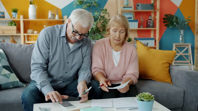 A couple reviewing household bills and receipts at home