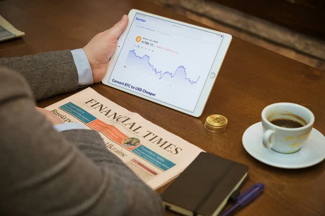 Reviewing financial charts on a tablet over coffee